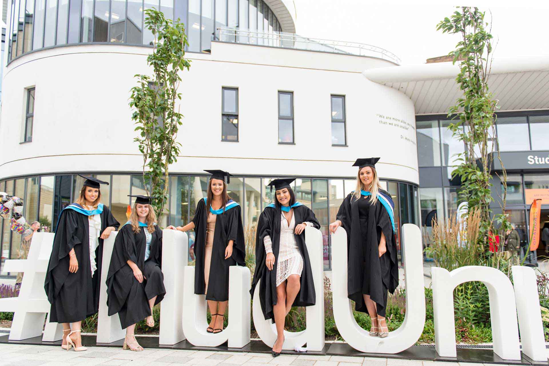 5 graduates on Hud Grad Prop with student central in the background